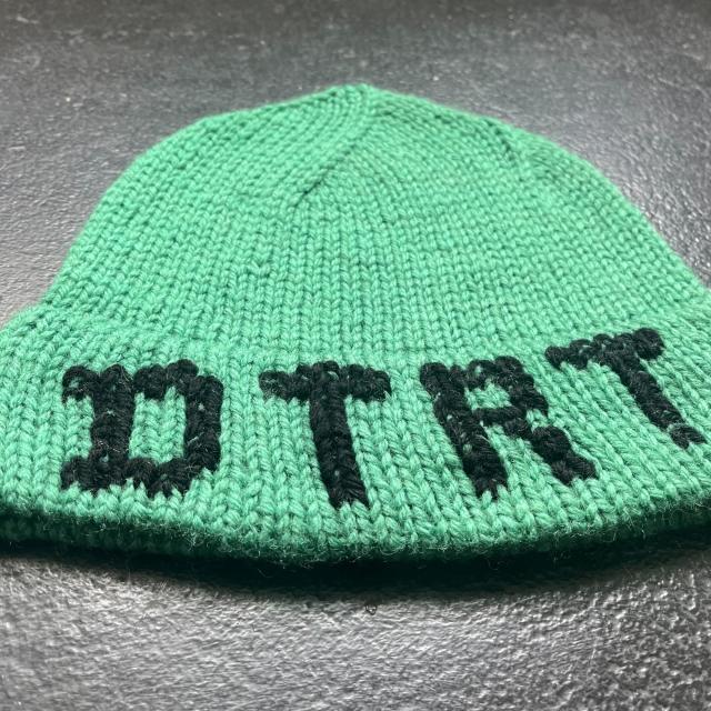 Do the write thing abbreviation sewed onto a green beanie 