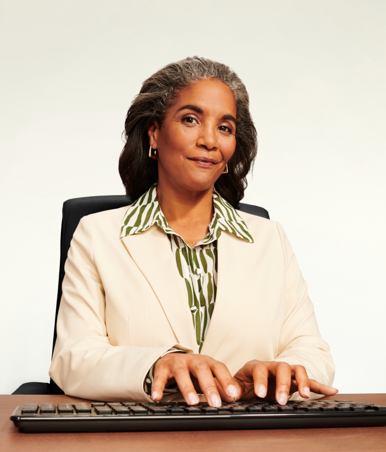 Confident woman/executive at a desk typing on a keyboard