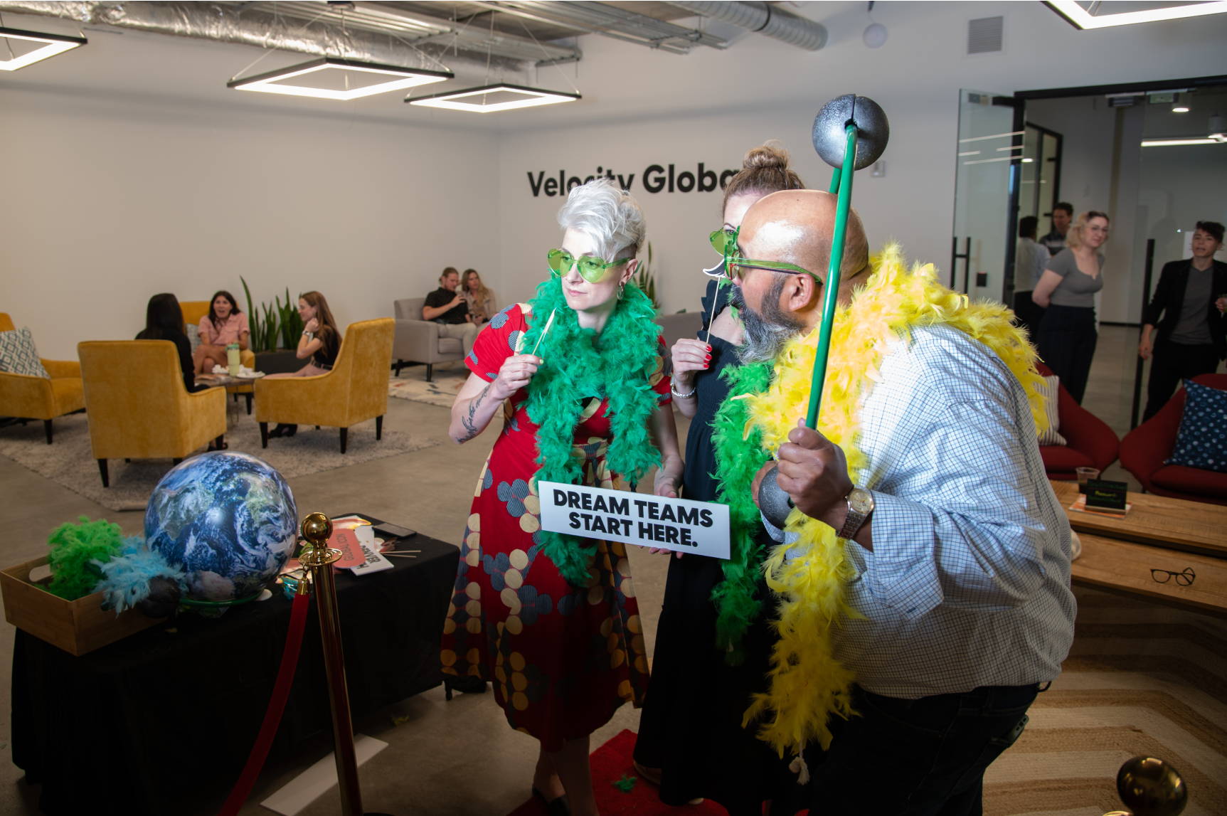 Velocity Global team members pose for a photo at a photo booth.