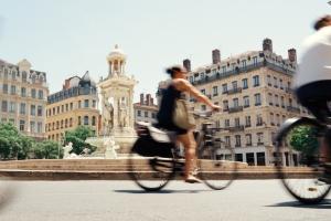 Woman biking next to the Fontaine des Jacobins in Lyon, France