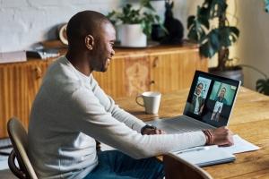 Man smiling while on a video call on his laptop