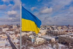 Ukrainian flag waving with city in the background