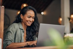 Female remote employee working happily on her laptop from home