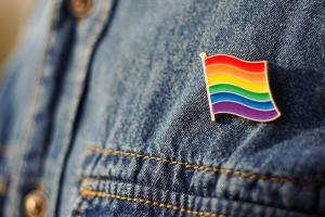 Pride rainbow flag button pinned on denim shirt
