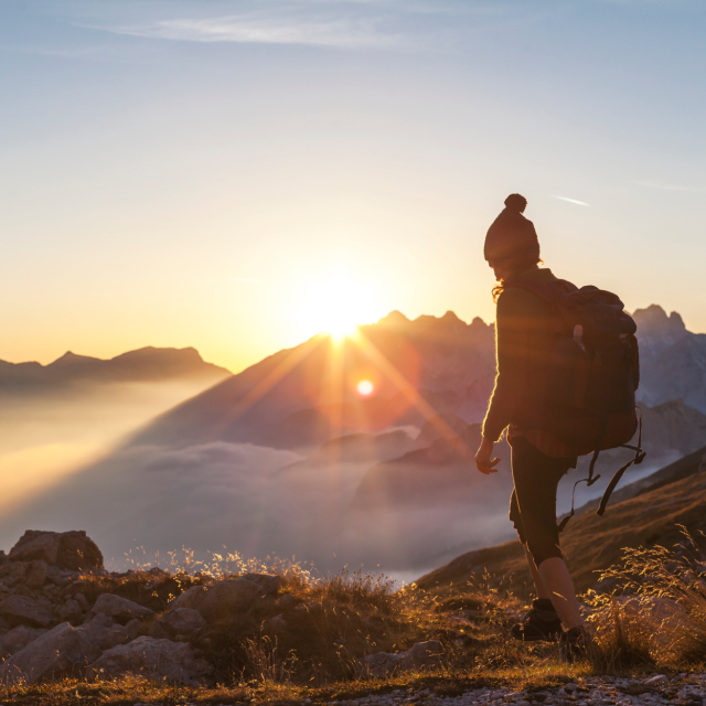 Person at the top of a mountain looking down at the clouds