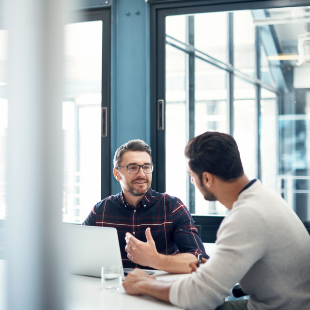 Two men talking to each other in an office