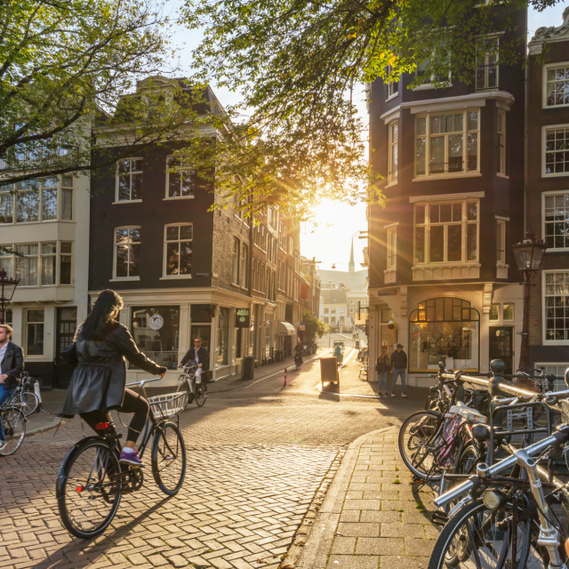 European city view with people walking and riding bicycles