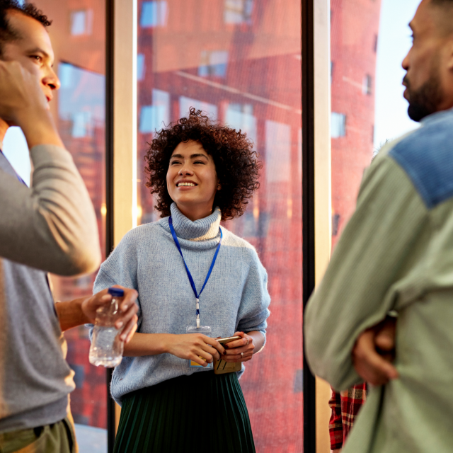 three people standing and chatting outside
