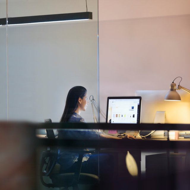 woman sitting at desk looking at laptop