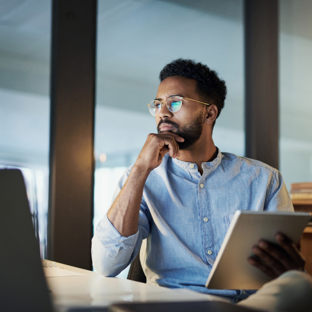 Man holding notebook looking at computer