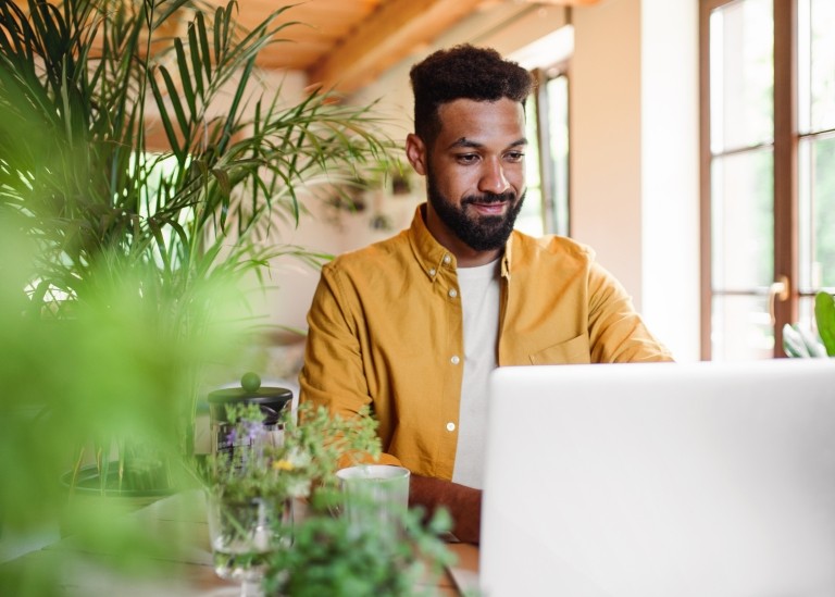 Man is working on laptop in cafe