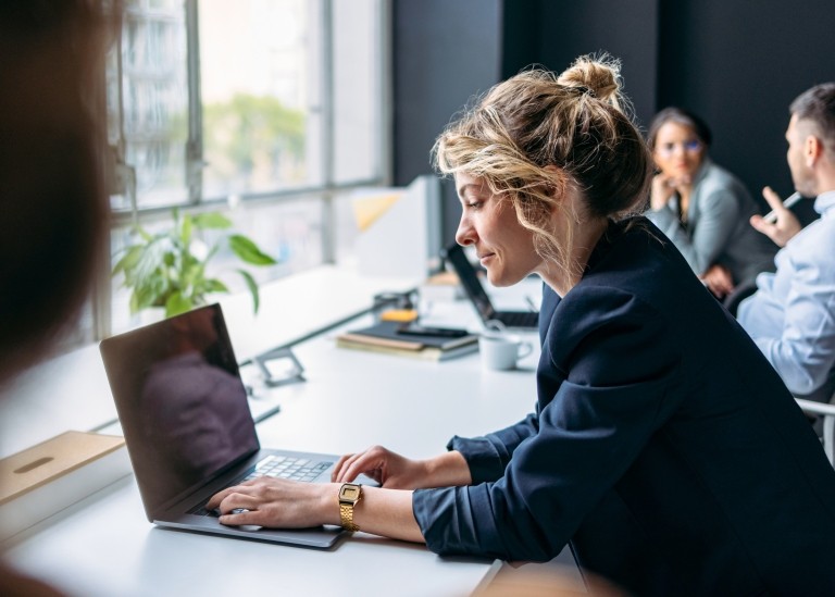 Woman working on her laptop in office building