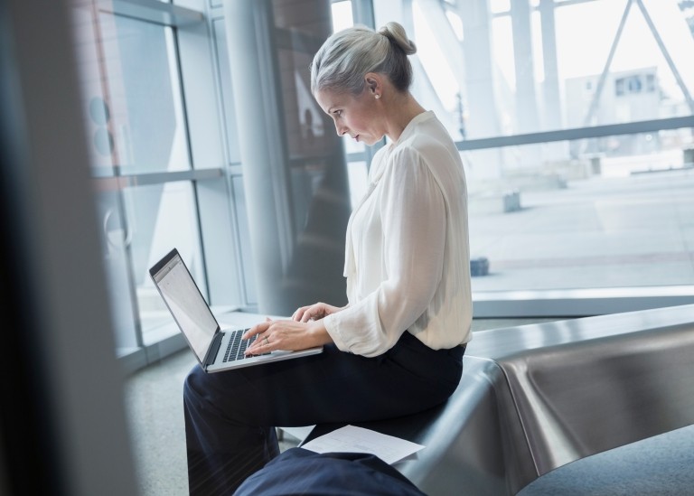 A hiring manager researching on her laptop the process of converting a contractor to an employee