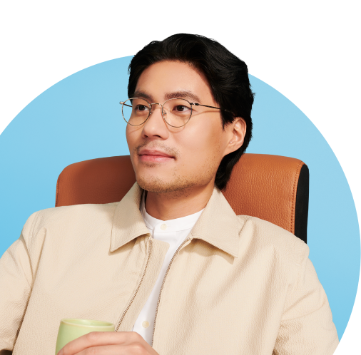 Man with glasses sitting on a chair with mug in hand