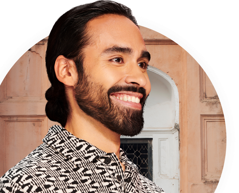 Man smiling with building behind him