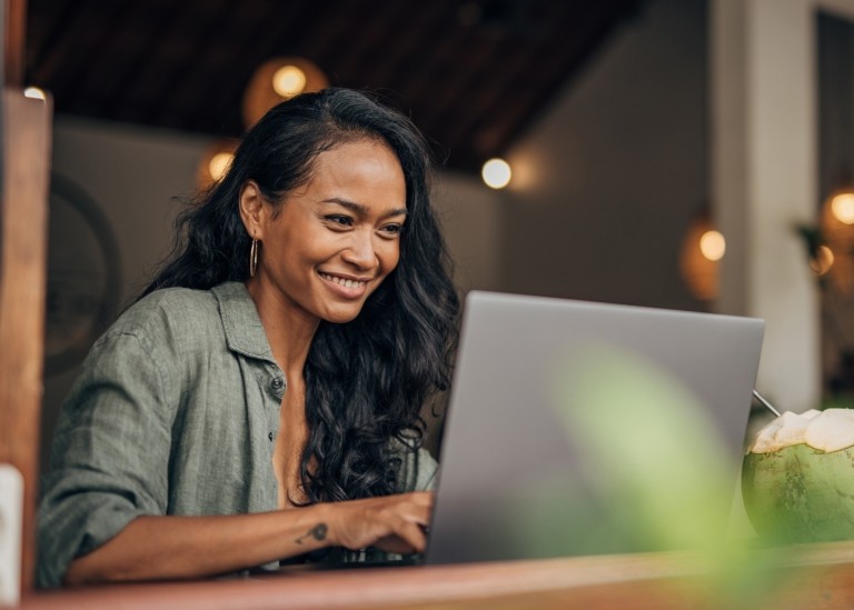 Female remote employee working happily on her laptop from home