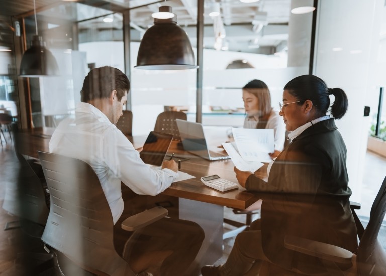 Three coworkers working together in a conference room in an office in Mexico