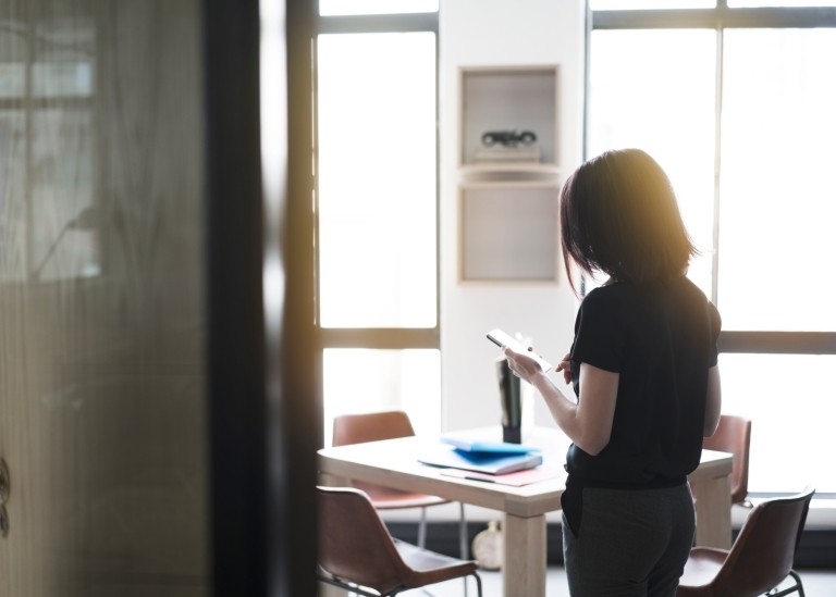 Female employee looking down at notepad inside of office