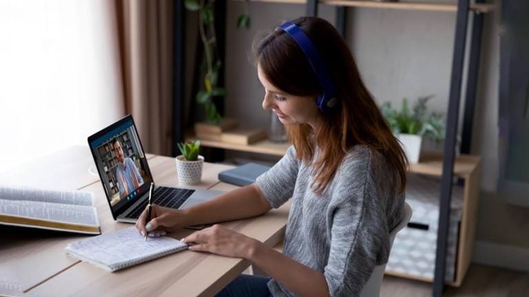 Woman conducting virtual meeting while working remotely