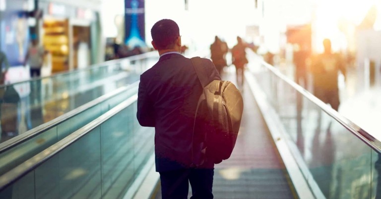 Man with briefcase on moving walkway in airport