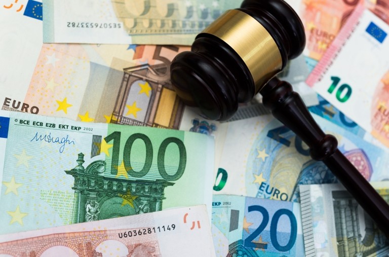 A gavel lying on top of various euro banknotes