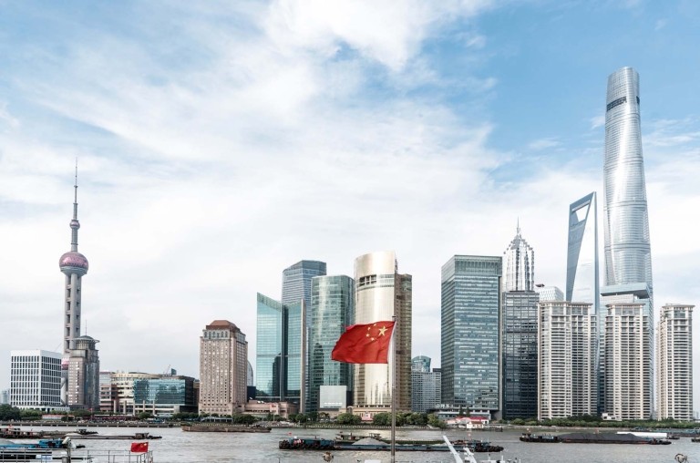 Shanghai, China skyline, Chinese flag at full staff in the center.