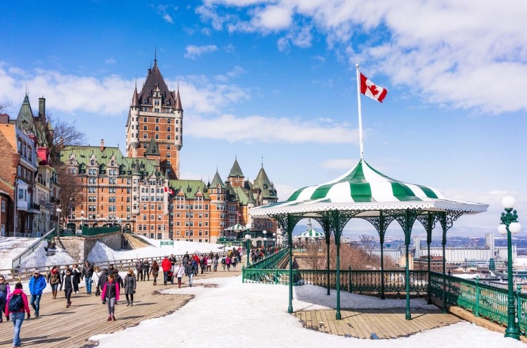 Candian city, snow on the ground, Canadian flag blowing in the wind