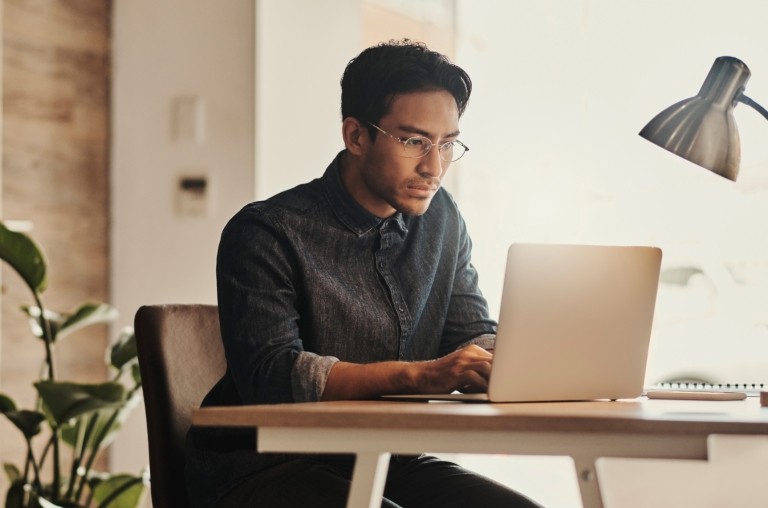 Remote employee works on his laptop from home