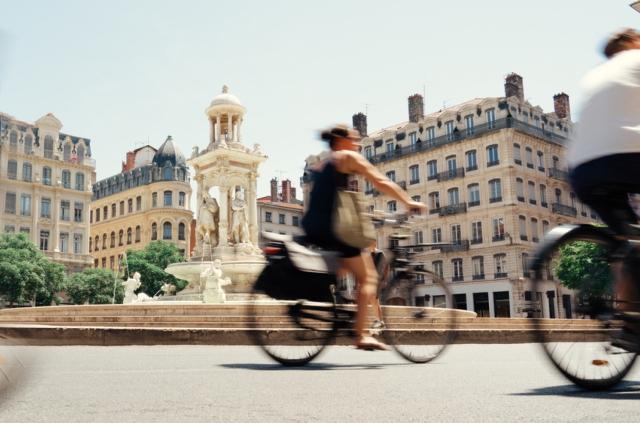 Woman biking next to the Fontaine des Jacobins in Lyon, France