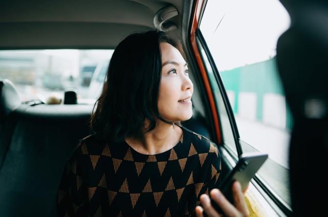 A busy CEO keeps track of her global workforce from the back of a cab because of the Velocity Global Global Work Platform™