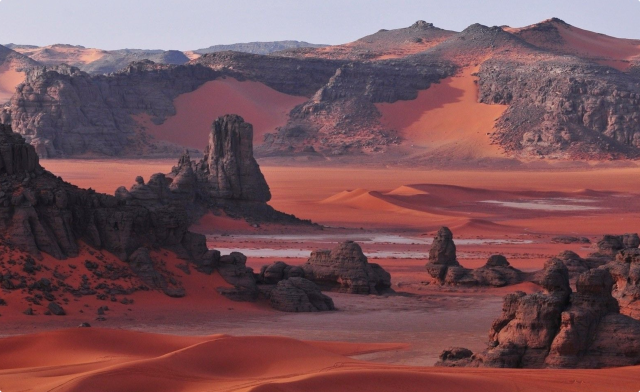 Red desert landscape with sand and rock