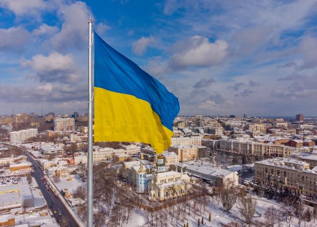 Ukrainian flag waving with city in the background