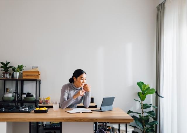 Woman looking at her laptop in her home office