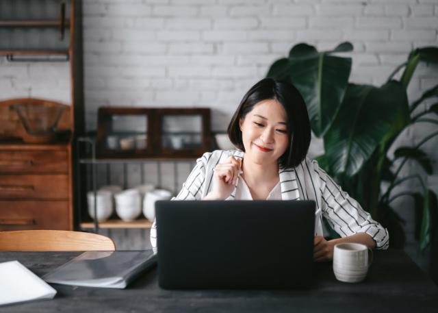 Remote employee enjoys a cup of coffee as she connects with her co-workers