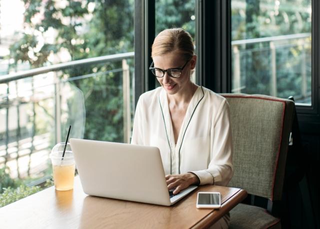 Relocated worker using her expat benefits by working from a cafe