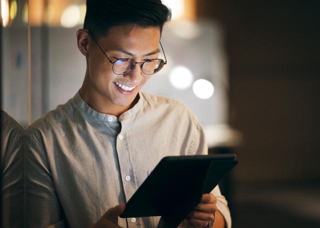 Male HR leader confidently reviewing a fixed-term employment contract for a new global hire on a tablet